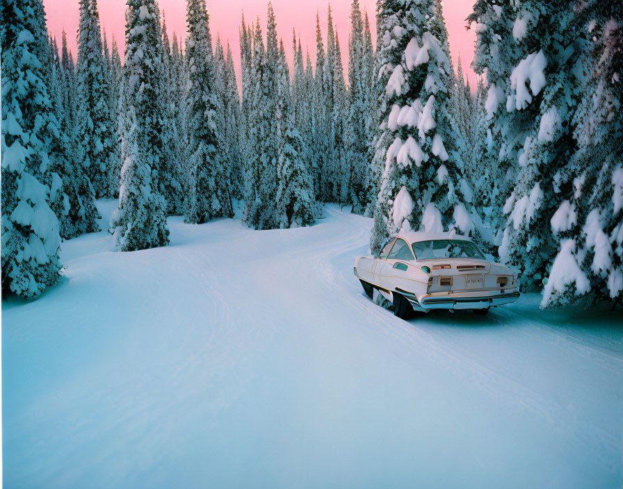 Vintage car on snow-covered forest road at dusk