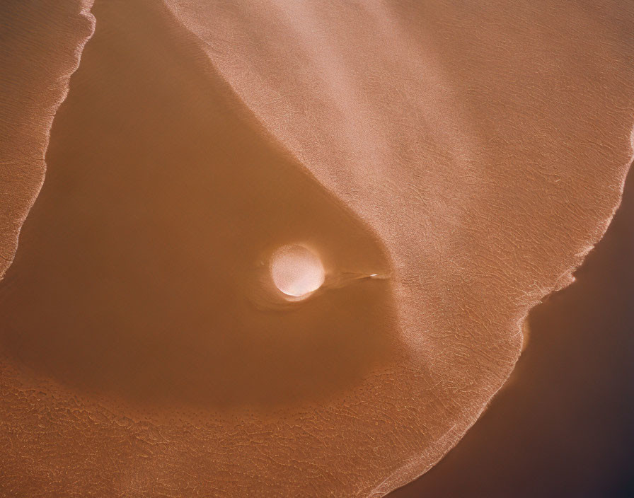 Sandy Beach with Circular Pattern and Gentle Waves