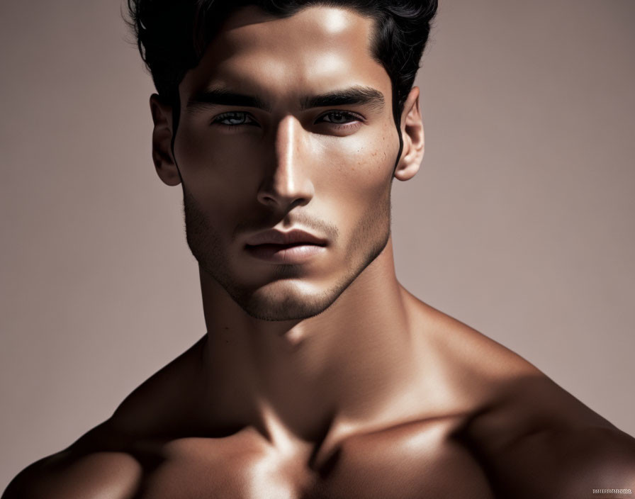 Chiseled male model with prominent cheekbones and stubble portrait.