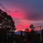 Solitary figure in front of vibrant sunset and starlit sky