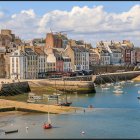 Seaside village watercolor: stone houses, boat, rolling hills, cloudy sky