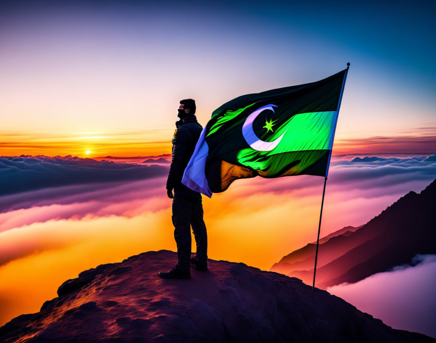 Person holding Pakistan flag on mountaintop at sunset with clouds and peaks.