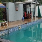 Family enjoying sunny day by serene pool with tropical foliage