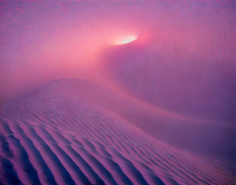 Sun partially obscured by haze above pink-lit sand dunes