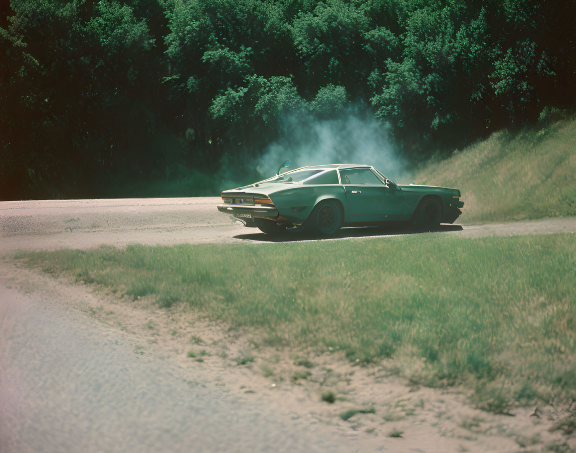 Vintage car speeding on dusty rural road with trees and dust trail.