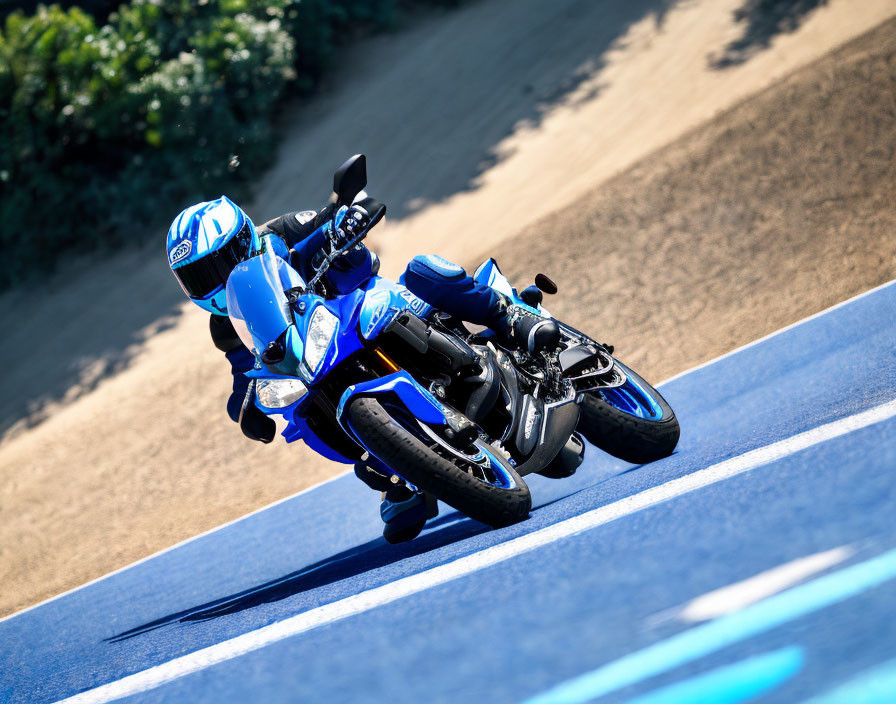 Motorcyclist in Blue and White Gear Riding on Blue Racetrack