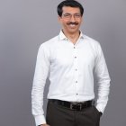 Smiling man in white shirt against gray background