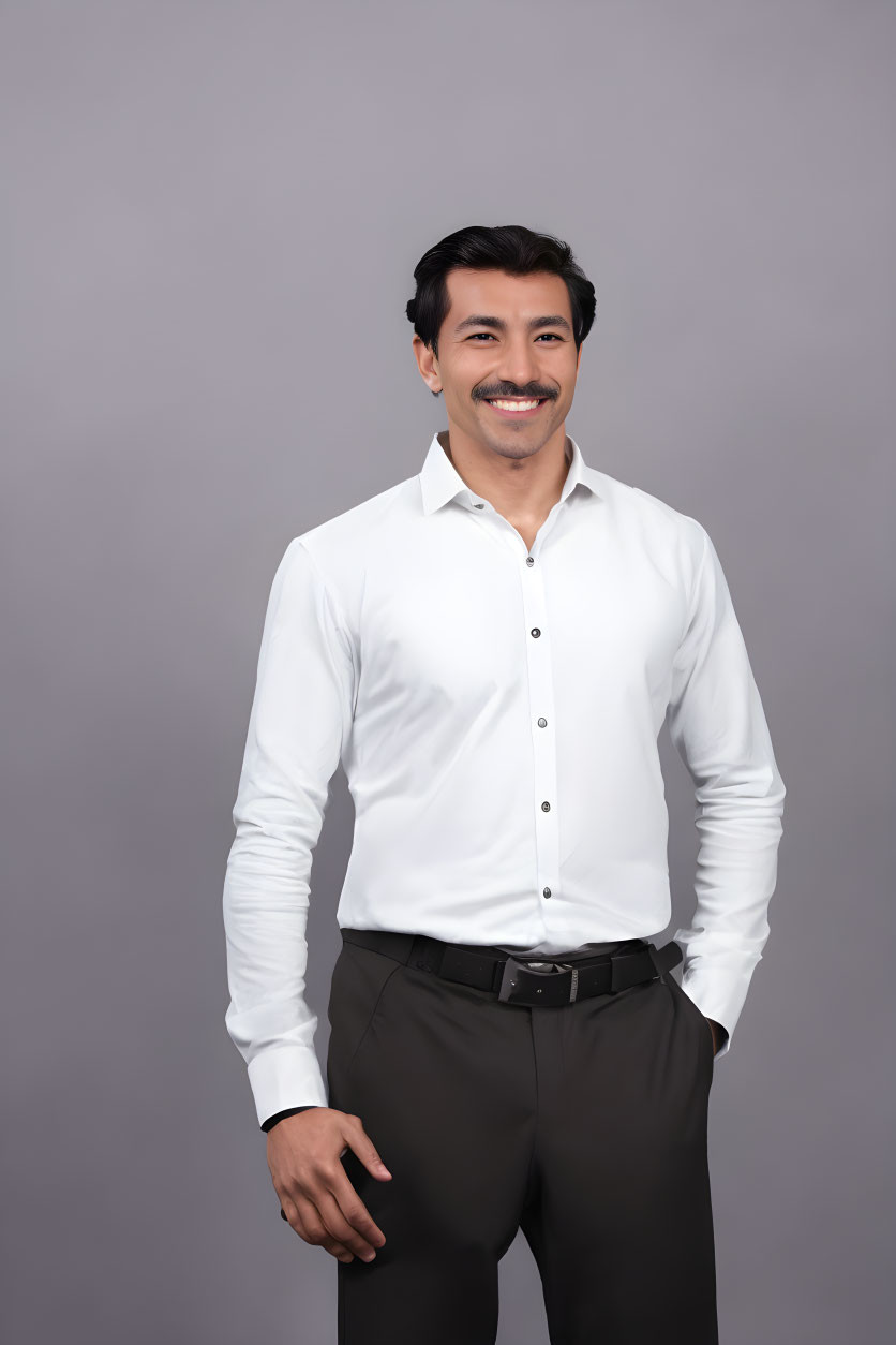 Smiling man in white shirt against gray background