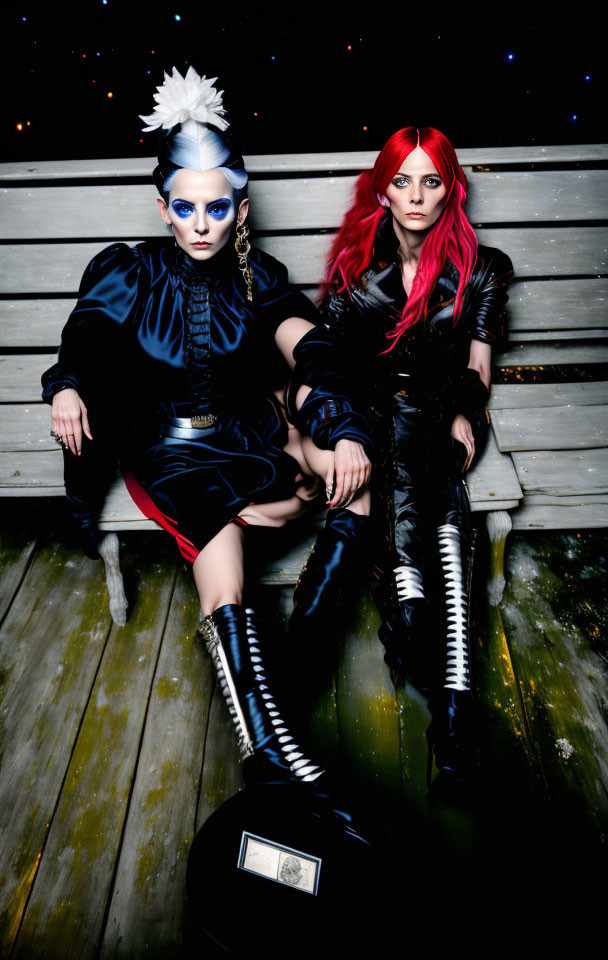 Colorful wigs and bold makeup on two individuals in avant-garde outfits sitting on bench