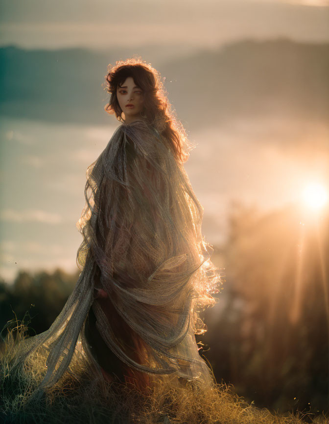 Woman in translucent shawl gazes over shoulder at sunset