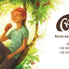 Child eating honey on tree branch under lush canopy with Cyrillic text logo.