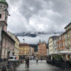 Digitally altered image: Couple in old European town square with baroque buildings under bubbly sky