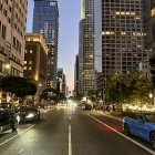 Urban scene with skyscrapers, canal, and vintage street lamp at twilight