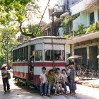 Vintage Tram, Motorbikes, and Cyclists in Busy Street Scene