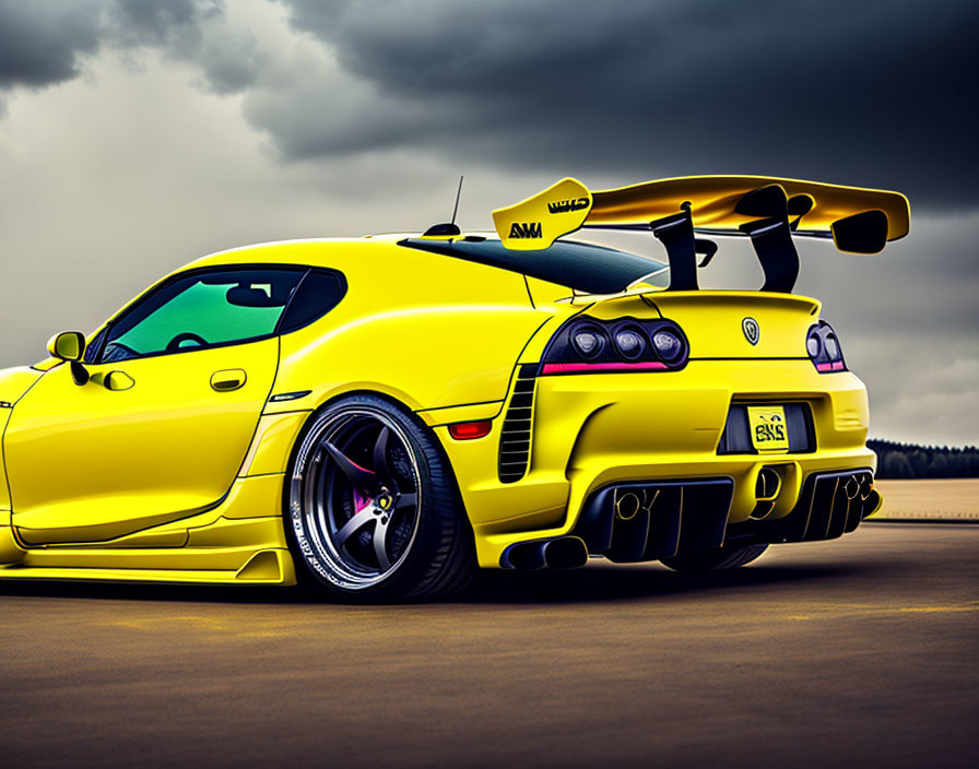 Customized Bright Yellow Sports Car with Large Spoiler on Asphalt Road