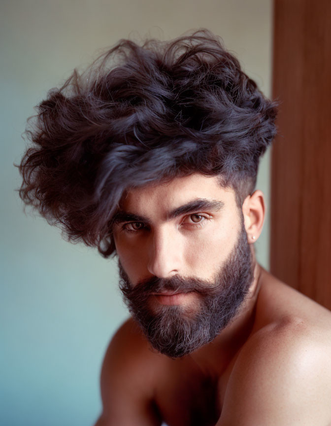 Bearded man with tousled dark hair and piercing eyes