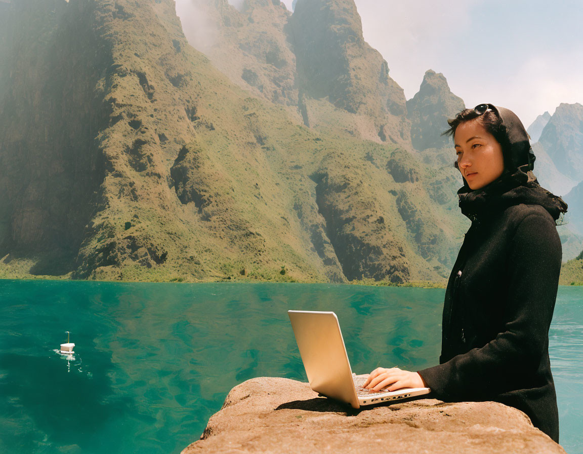 Person in Black Outfit Works on Laptop by Mountain Lake on Sunny Day