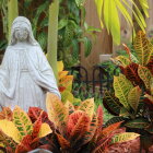 Tranquil garden scene with stone statue, flowers, and planters