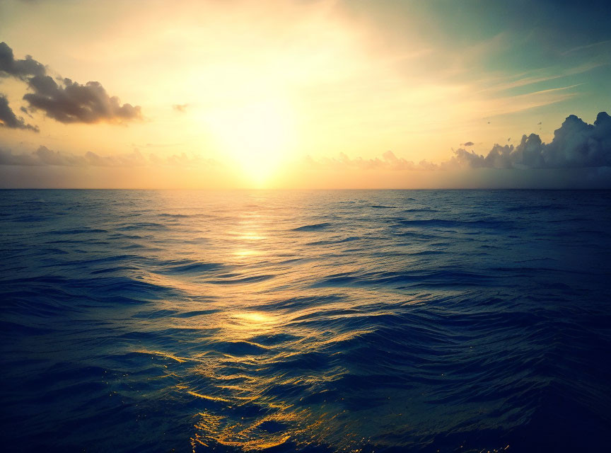 Scenic sunset over ocean with golden light and clouds