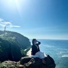 Surreal landscape featuring woman, vibrant flora, birds, sea, starry sky.