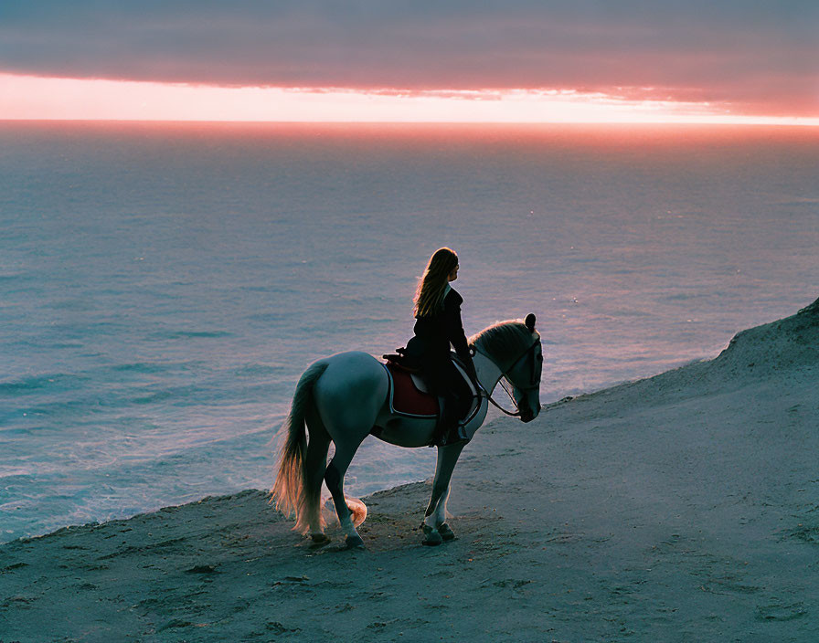 Equestrian on Horseback on Cliff Overlooking Ocean at Sunset