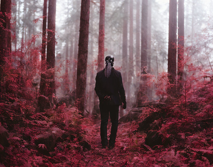 Figure in Skull Mask Stands in Misty Red Forest