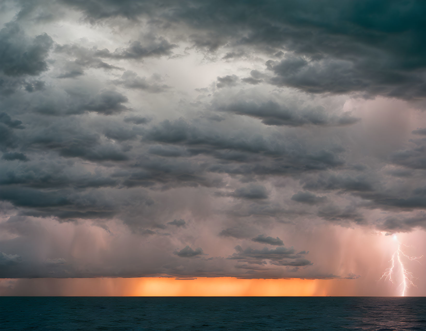 Dramatic ocean storm at sunset with dark clouds and lightning bolt