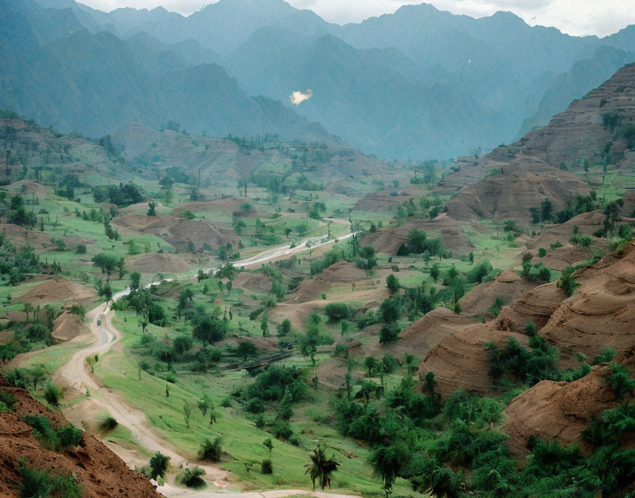 Scenic winding road through lush green valley and mountains