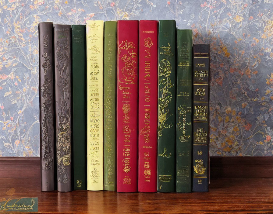 Colorful Hardcover Books with Gold Lettering on Wood Surface