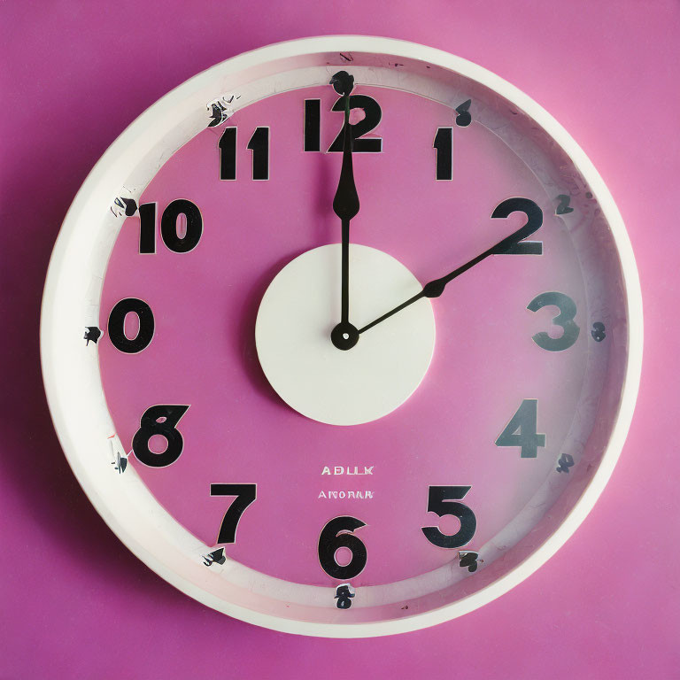 Pink Wall Clock with Black Numbers and Hands on Pink Background