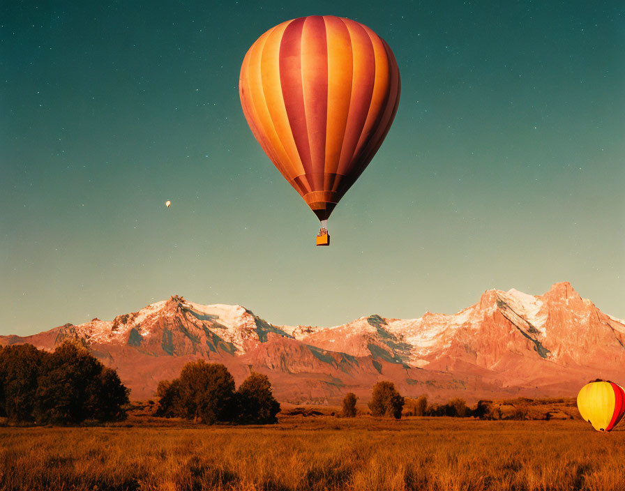 Twilight sky hot air balloon over snow-capped mountains