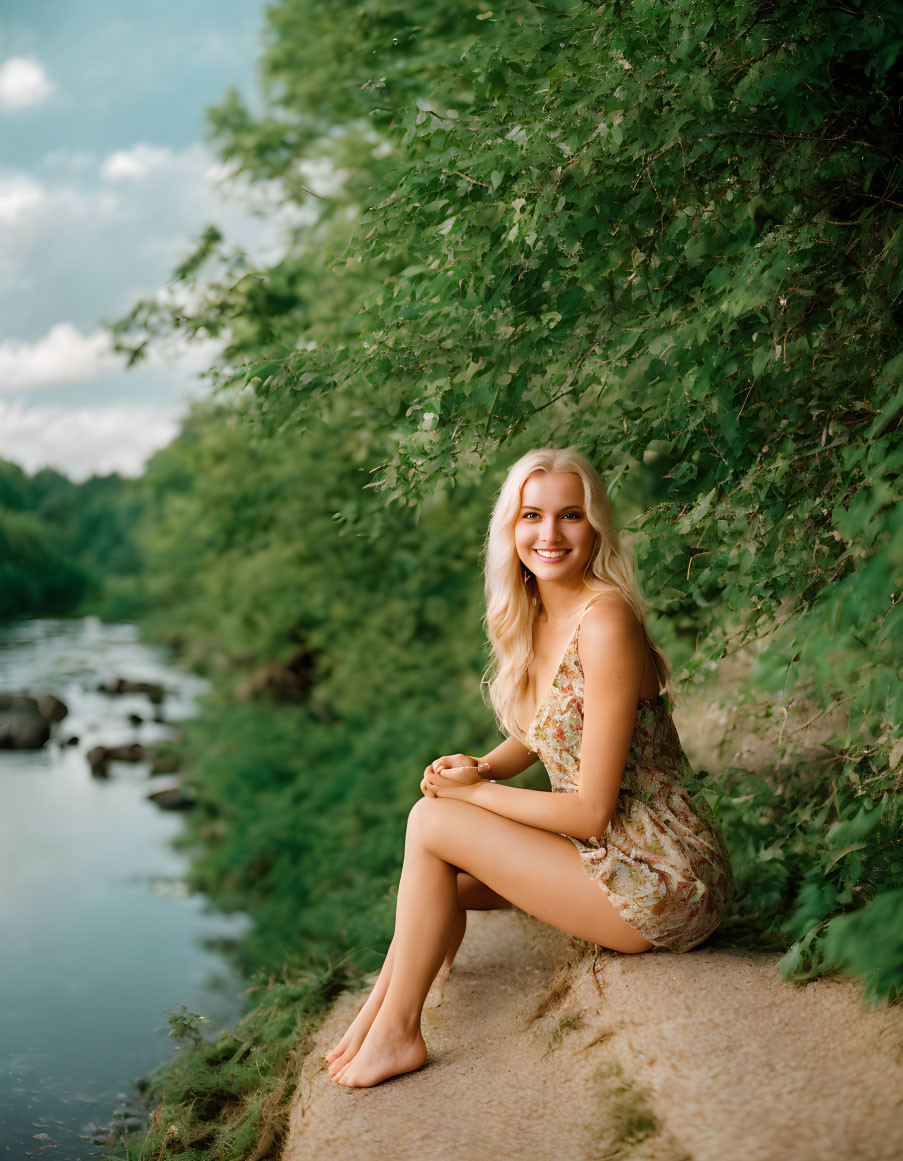 Smiling woman in floral dress by riverbank