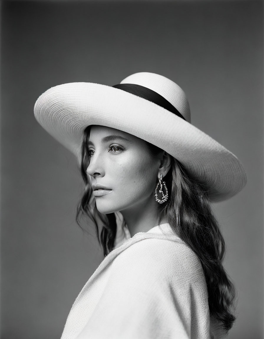 Monochrome portrait of woman in wide-brimmed hat with textured top