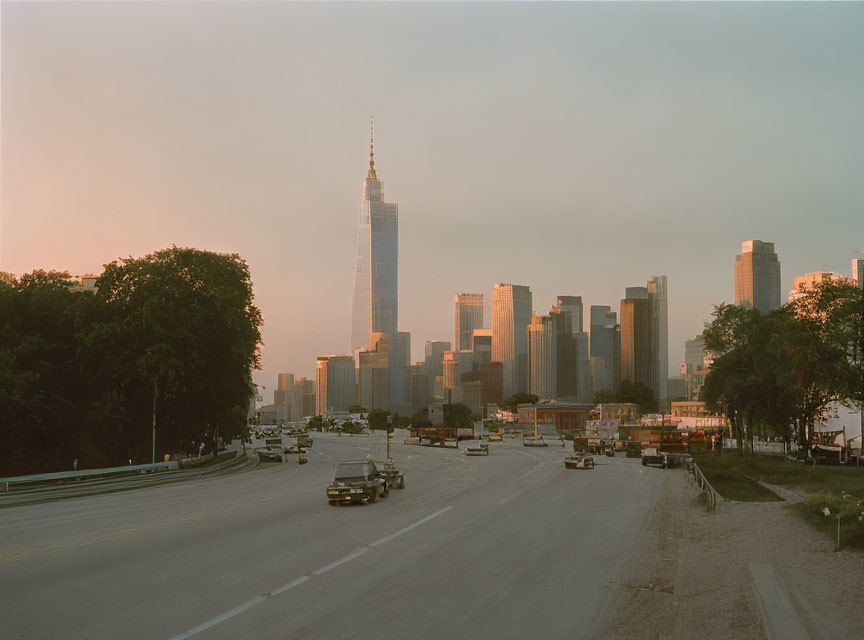 Cityscape at Dawn/Dusk with Skyscraper, Sunlit Buildings, and Empty Highway