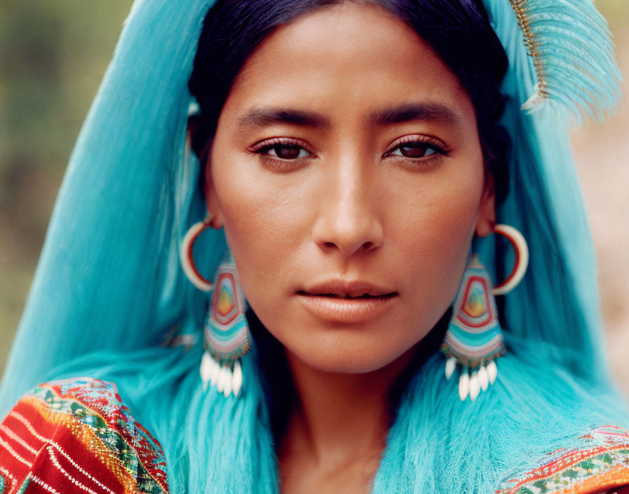 Pensive woman with blue headgear and hoop earrings in colorful attire