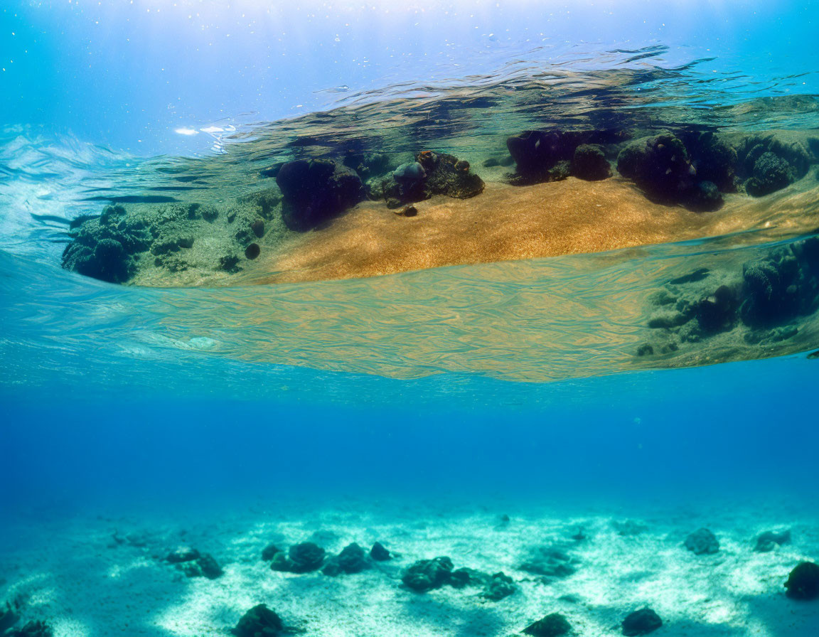 Clear Blue Sea with Sunlight Reflecting on Sandy Ocean Floor