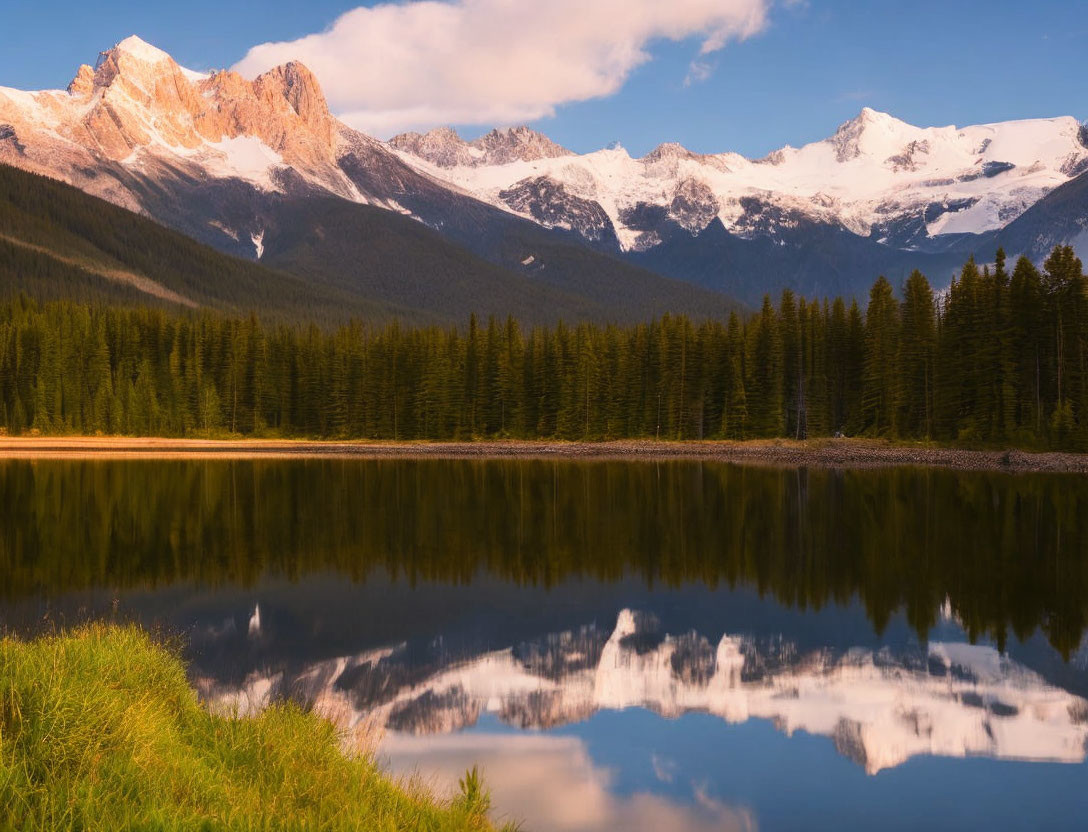 Snowy Peaks and Forest Reflected in Mountain Lake at Sunrise