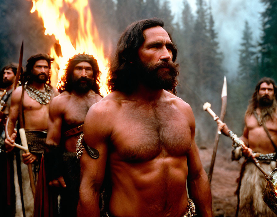 Actors in ancient warrior costumes on movie set with fire in hazy woods