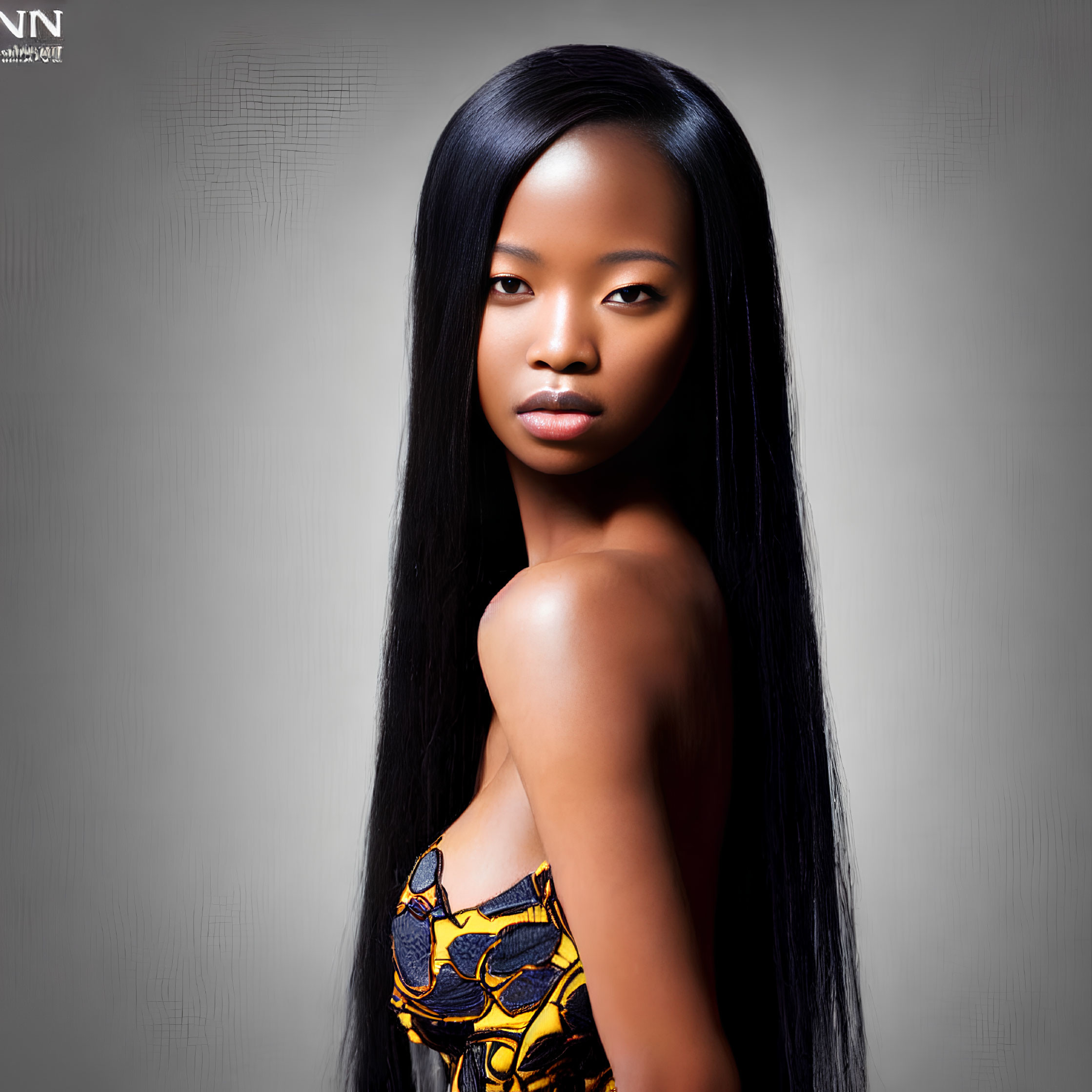 Portrait of Woman with Long Straight Hair in Colorful Top on Grey Background