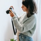 Stylized female figure in blue and gold costume with camera and potted plant