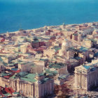 Classical architecture and domed buildings in coastal cityscape.