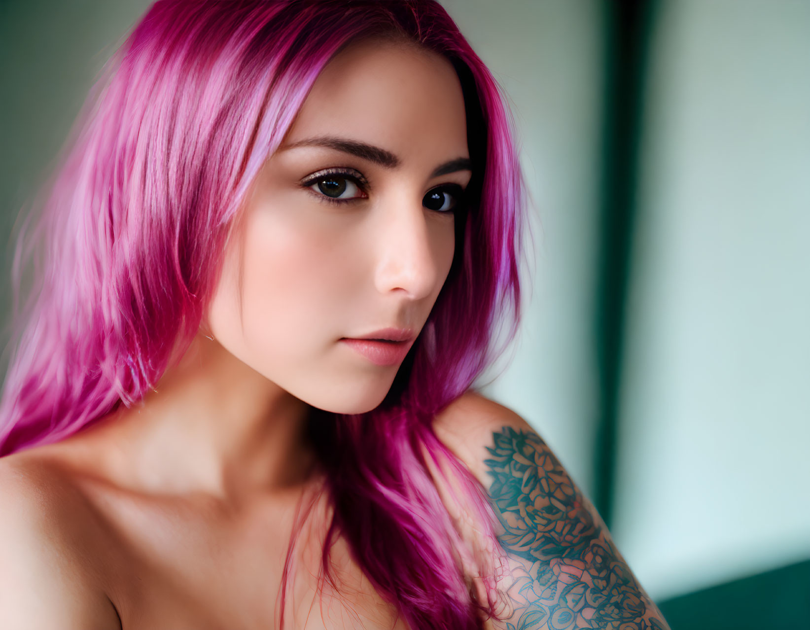 Person with Bright Pink Hair and Tattoo Gazing at Camera