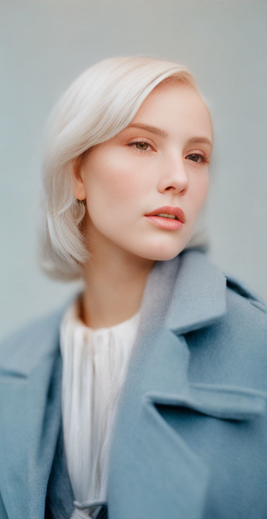 Portrait of woman with platinum blonde hair in blue coat