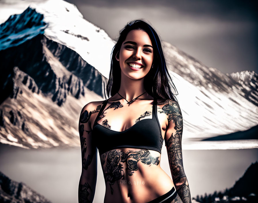 Smiling woman with arm tattoos against snowy mountains