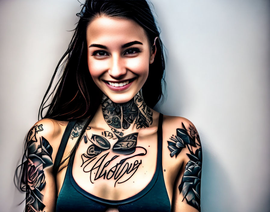 Tattooed Woman Smiling in Tank Top on Light Background