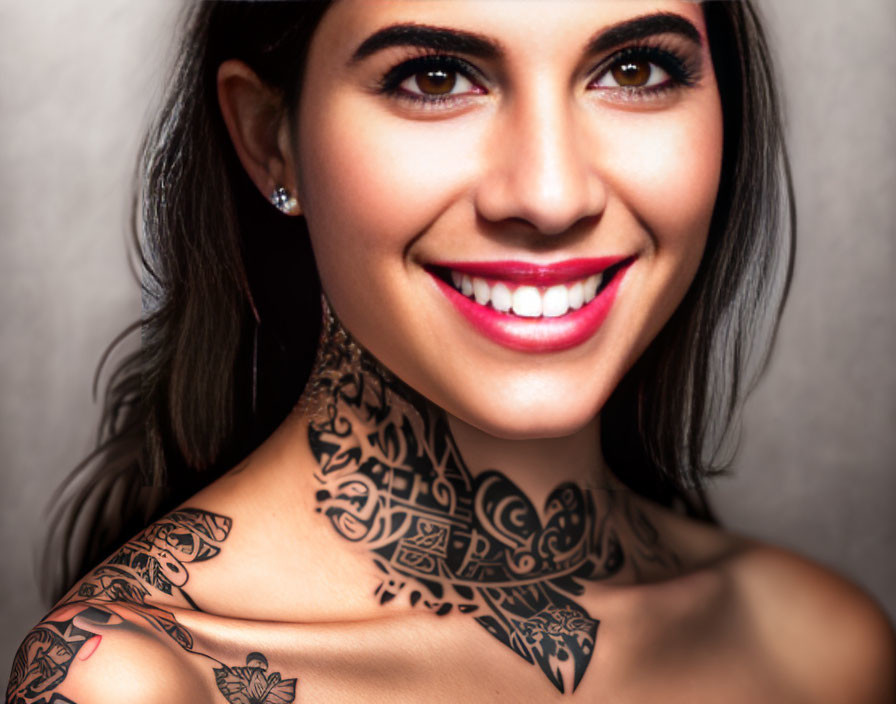 Smiling woman with red lipstick and tattoo on gray background