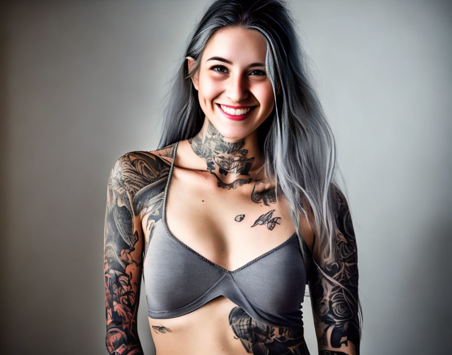 Grey-Haired Woman with Extensive Tattoos in Grey Top on Gradient Background