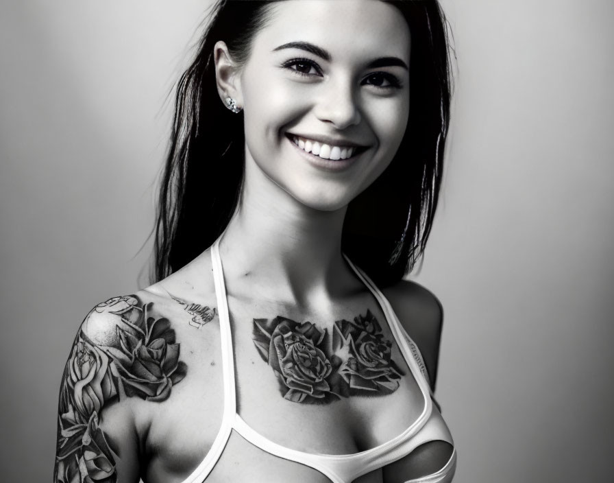 Monochrome portrait of smiling woman with floral tattoos