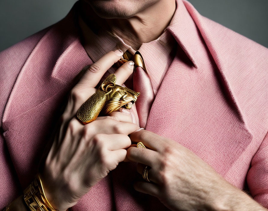 Person in Pink Shirt Adjusting Large Gold Lion Pendant & Accessories