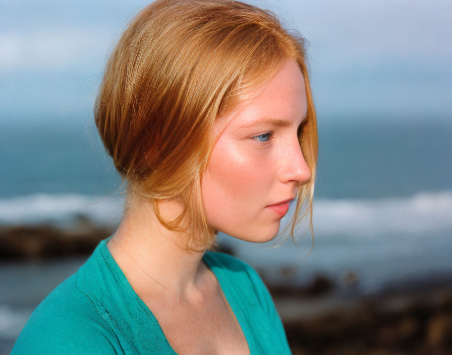 Red-Haired Woman in Profile with Teal Top by Ocean and Sky